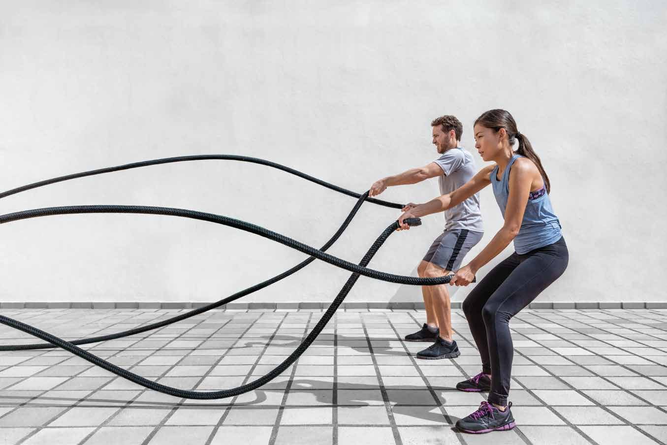 Two athletes training with battle ropes