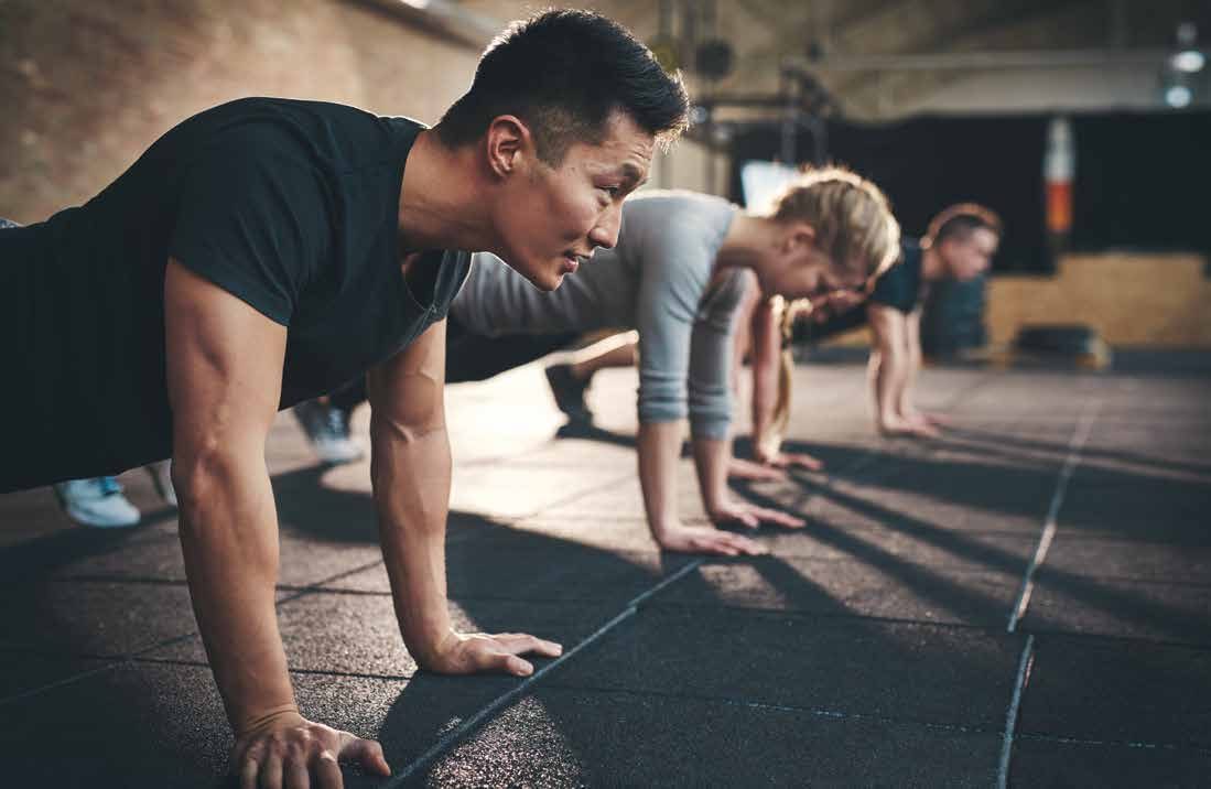 Group class holding a plank position on the dojo floor